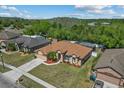 Well-maintained home featuring a brown roof, manicured lawn, and screened-in pool in a scenic neighborhood at 2721 Village Pine Ter, Orlando, FL 32833