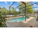 Private screened-in pool area surrounded by lush landscaping at 2721 Village Pine Ter, Orlando, FL 32833