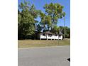 Picture of a one-story house from a street view surrounded by trees and showcasing its quaint design at 303 E 13Th St, Apopka, FL 32703