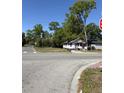 View of quaint residence, showing its location at an intersection with trees and surrounding landscape at 303 E 13Th St, Apopka, FL 32703