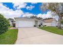 Inviting one-story home featuring a lush green lawn, easy driveway access and attached garage at 344 China Berry Cir, Davenport, FL 33837