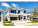 Elegant two-story home with a modern facade, a balcony, and a well-manicured front yard at 960 Jack Nicklaus Ct, Kissimmee, FL 34747