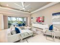 Bright and airy living room with a modern ceiling fan, sleek furnishings, and views of the outdoor pool at 960 Jack Nicklaus Ct, Kissimmee, FL 34747