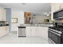 Bright kitchen with white cabinets, stainless steel appliances, granite countertops, and tile flooring at 1056 Royal Saint George Dr, Orlando, FL 32828