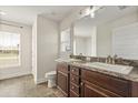 Bright bathroom features a double sink vanity, marble countertops and a window letting in plenty of natural light at 2257 Pecos Ct, Kissimmee, FL 34759