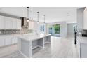 Bright, open kitchen features an island, stainless steel appliances and sliding glass doors to the backyard at 2661 Estuary Loop, Oviedo, FL 32765