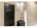 A front view of the black entrance door with the unit number and an outdoor light fixture at 1321 Arbor Vista Loop # 101, Lake Mary, FL 32746