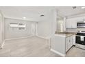 Open-concept living space with light gray walls, stylish floors and an eat-in kitchen bar at 1475 Lowrie Ave, Orlando, FL 32805