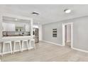 Open-concept living space with light gray walls, stylish floors and an eat-in kitchen bar at 1475 Lowrie Ave, Orlando, FL 32805