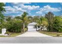 Inviting single-story home with a private driveway, a two-car garage, and mature trees under a cloudy sky at 19261 Quarterly Pkwy, Orlando, FL 32833