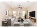 Bright living room featuring neutral tones, stylish furnishings, a ceiling fan, and plenty of natural light at 19261 Quarterly Pkwy, Orlando, FL 32833