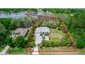 Aerial view of a single-story home on large lot, surrounded by trees and a lake nearby at 19261 Quarterly Pkwy, Orlando, FL 32833