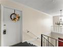 Hallway at top of the stairs with a door decorated with a floral wreath and a decorative hanging light fixture at 200 St Andrews Blvd # 512, Winter Park, FL 32792