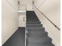 Carpeted staircase with sleek metal railings leading to the upper level of the home at 200 St Andrews Blvd # 512, Winter Park, FL 32792