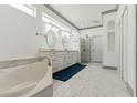 Elegant bathroom with double vanity, glass shower, soaking tub, and marble tile flooring at 2328 Warren Woods Dr, Orlando, FL 32835