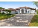 Beautiful single-story home with a brick paved driveway, attached garage, and manicured landscaping at 2328 Warren Woods Dr, Orlando, FL 32835