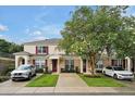 Attractive townhome featuring neat lawn, red shutters and a flowering shade tree at 2355 Silver Palm Dr, Kissimmee, FL 34747