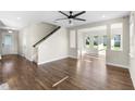 Open-concept living room with hardwood flooring, staircase, fan, and great natural light, offering a seamless flow at 2383 Regency Park Dr, Deland, FL 32724