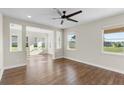 Spacious living room with hardwood floors, a ceiling fan, and bright windows overlooking the backyard at 2383 Regency Park Dr, Deland, FL 32724