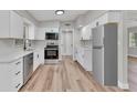 Well-lit kitchen featuring modern appliances, white cabinets, and stylish backsplash at 2417 Healy Dr, Orlando, FL 32818