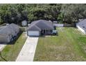 Aerial view of a well-kept house with a long driveway and large backyard surrounded by trees at 271 W 11Th St, Chuluota, FL 32766