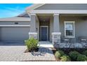Inviting front porch featuring decorative stone pillars, cozy seating, and a charming entrance at 2837 Darlington Oak Ln, Ocoee, FL 34761