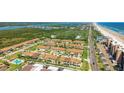 An aerial view of a neighborhood located near the beach and a lake, palm trees, and a community pool at 33 Sea Haven Dr, Ponce Inlet, FL 32127