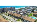 An aerial view of townhomes with ocean views, palm trees, and neighborhood pool at 33 Sea Haven Dr, Ponce Inlet, FL 32127
