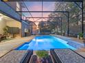 Stunning screened-in pool with lounge chairs, waterfall feature and beautiful landscaping, perfect for relaxation at 3637 Chandler Estates Dr, Apopka, FL 32712