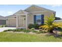 Attractive one-story home with a manicured lawn and beautiful landscaping at 4718 Magnetite Loop, Mount Dora, FL 32757
