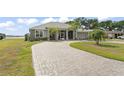 Spacious home with a long driveway, lush lawn, and partial lake views at 720 Basin Dr, Kissimmee, FL 34744