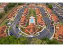 Aerial view showcasing community layout, centralized pool, colorful buildings, parking, and lush landscaping at 979 Park Terrace Cir, Kissimmee, FL 34746