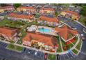 Community aerial view featuring swimming pool, lush landscaping, colorful buildings and ample parking space at 979 Park Terrace Cir, Kissimmee, FL 34746