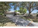 Charming single-story home surrounded by mature trees with a two-car garage, and driveway at 9900 W Lake Marion Rd, Haines City, FL 33844