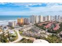 Aerial view of townhomes near the beach, hotels, and commercial buildings under blue skies at 106 Oceans Cir, Daytona Beach, FL 32118