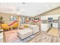 Open-concept living area featuring modern decor, hardwood floors, and a kitchen with white cabinets at 106 Oceans Cir, Daytona Beach, FL 32118
