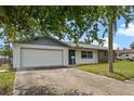 Attractive single-story home showcasing an attached garage and a well-maintained lawn at 10900 Tangora St, Orlando, FL 32825
