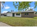Inviting single-story home featuring a well-manicured lawn and eye-catching stone accents at 10900 Tangora St, Orlando, FL 32825