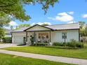 Charming exterior of home with a metal roof, landscaped lawn, and a lovely front porch sitting area at 1136 W Harvard St, Orlando, FL 32804