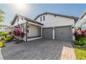 Attractive two-story home with a manicured lawn, gray two-car garage doors, and covered porch at 15313 Lebeau Loop, Winter Garden, FL 34787