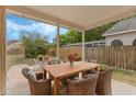 Charming covered patio with wooden dining table and six cushioned chairs, perfect for outdoor entertaining and relaxation at 2051 Pernod Ct, Apopka, FL 32703