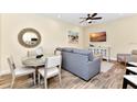 Comfortable living area with dining table, flatscreen TV, and stylish decor with wood look flooring at 3205 Caribbean Soul Dr, Kissimmee, FL 34747