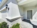 Covered entryway showcases a modern front door, stylish lighting, and elegant stone detailing at 3273 Lilac Way, Davenport, FL 33897