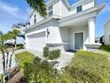 Attractive front entry featuring a covered porch, stone accents, and lush landscaping at 3273 Lilac Way, Davenport, FL 33897