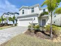 Inviting home exterior showcasing a well-kept lawn, mature landscaping, and a spacious two-car garage at 3273 Lilac Way, Davenport, FL 33897