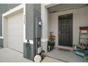 Inviting covered front entryway with landscaping and view of the garage at 5367 Pinecone Ct, Wildwood, FL 34785