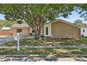 Charming home featuring stone accents, a well-manicured lawn, and mature landscaping at 5441 Justine Way, Winter Park, FL 32792
