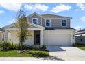 Two-story home with neutral stucco, stone accents, a two-car garage and manicured lawn at 640 Trotters Dr, Eagle Lake, FL 33839