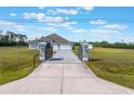 Beautiful single-story home with a well-manicured lawn and a concrete driveway with a gated entrance at 6607 Whispering Pines Rd, Orlando, FL 32824