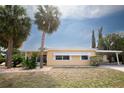 Relaxing home boasting mature palm trees, a carport, and a well-maintained lawn at 726 Viking Ave, Tavares, FL 32778